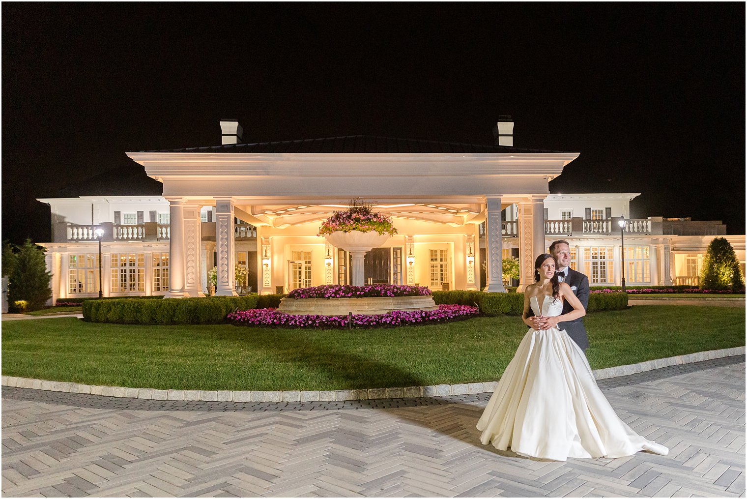bride and groom pose for photos outside Shadowbrook at Shrewbsury at night