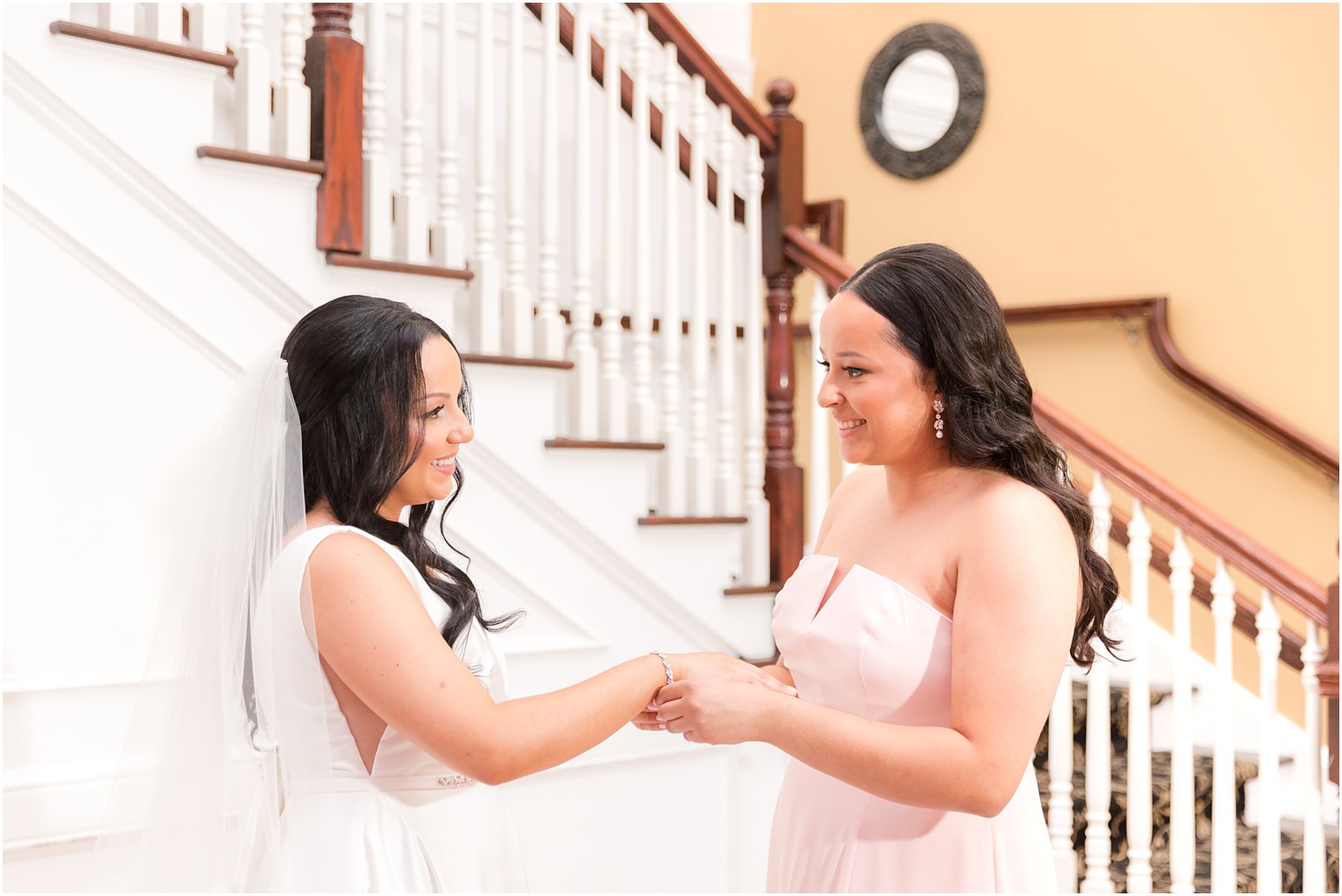 bridesmaid helps bride with bracelet on wedding morning