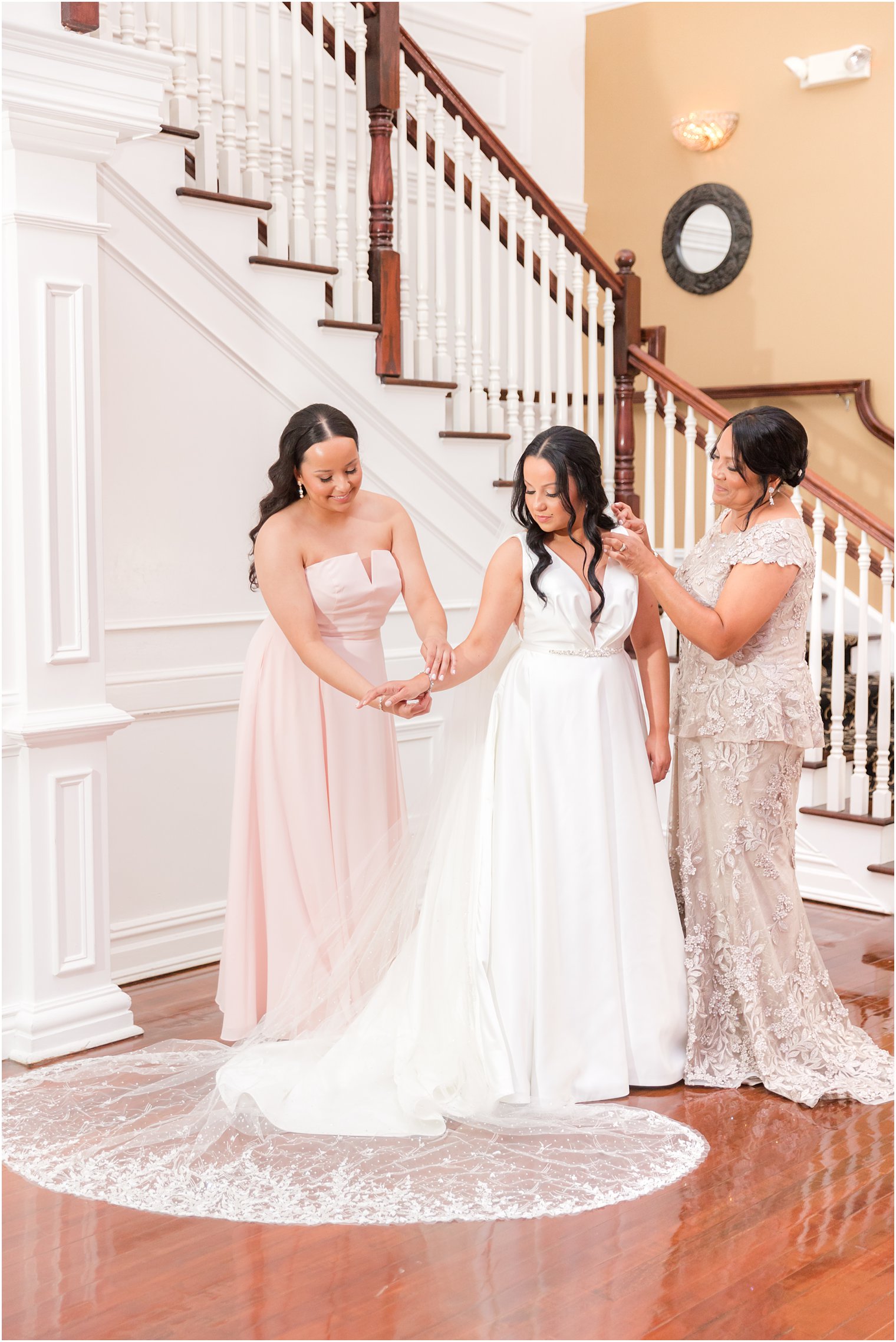 mother helps bride into wedding dress before Hamilton Manor wedding