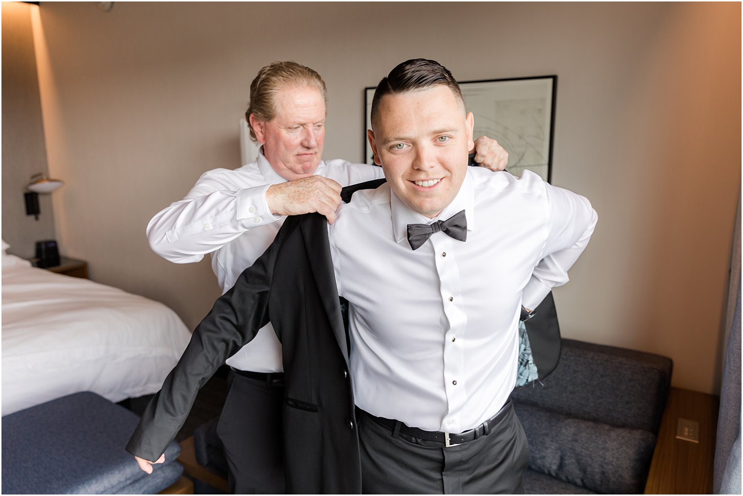 father helps groom into jacket before NJ wedding
