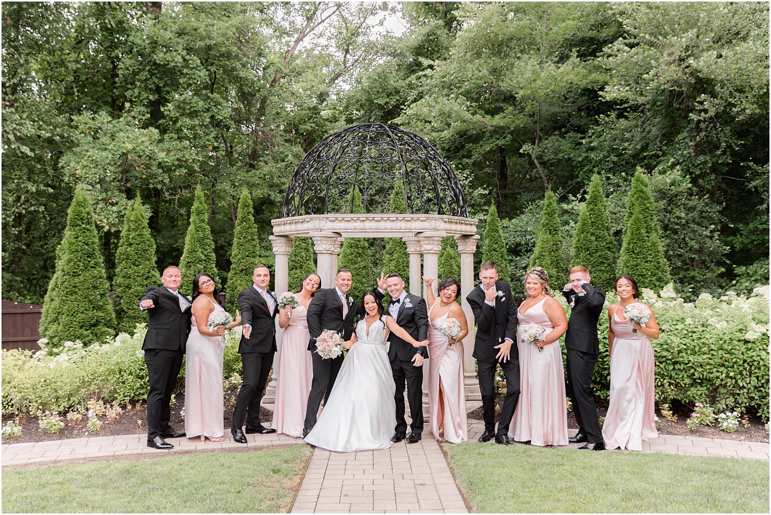 newlyweds pose with wedding party by gazebo at Hamilton Manor