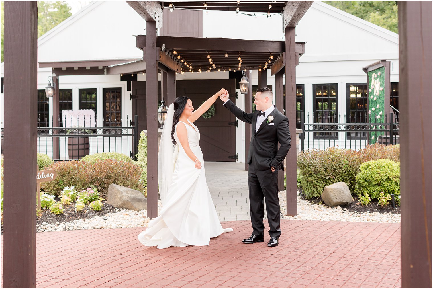 groom twirls bride outside Hamilton Manor