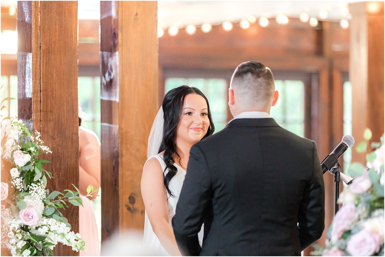 bride smiles at groom during rustic wedding ceremony at Hamilton Manor