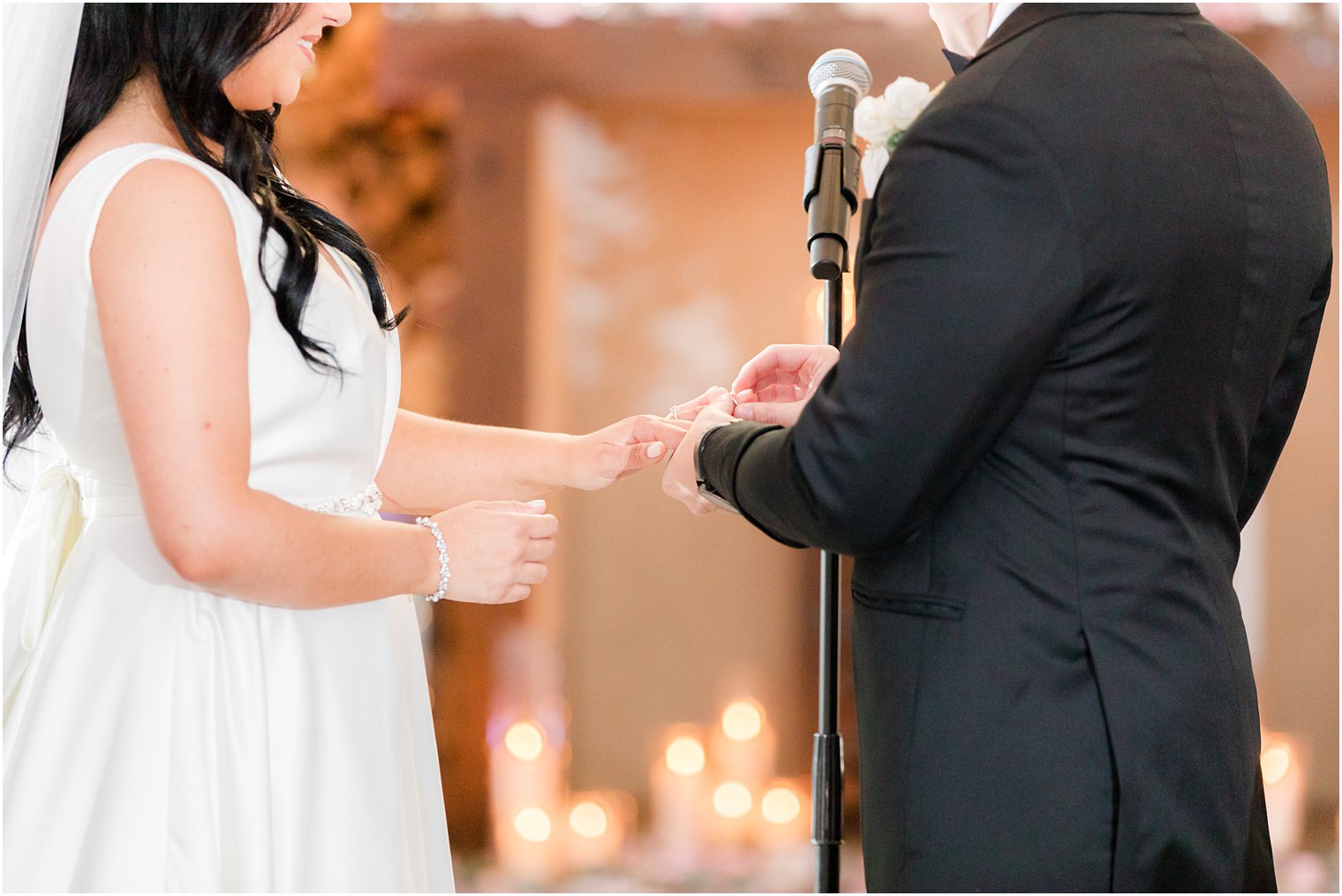 groom puts ring on bride during rustic wedding ceremony at Hamilton Manor