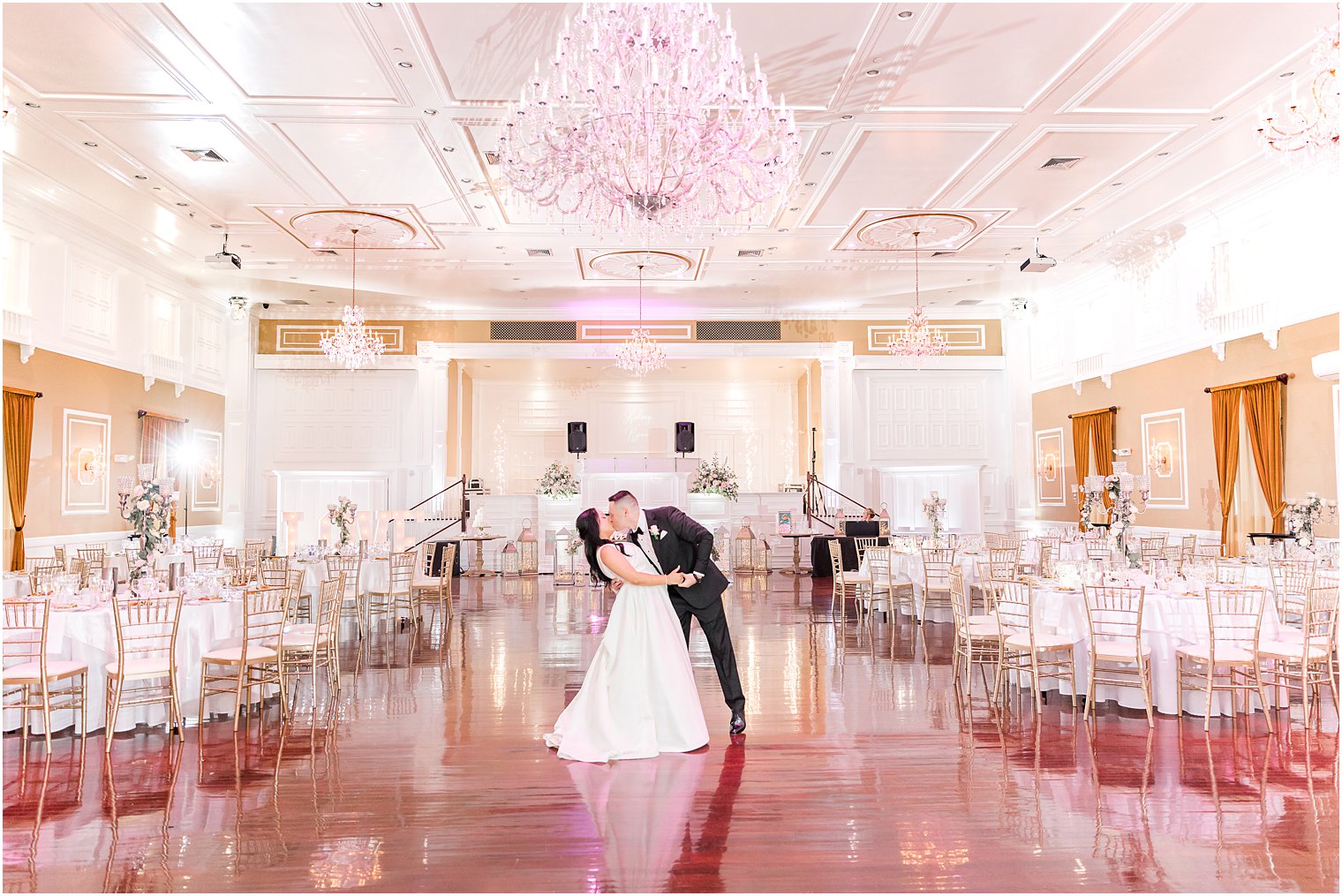 bride and groom kiss in empty ballroom at Hamilton Manor