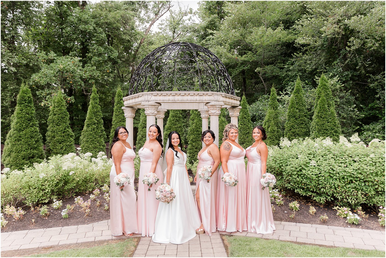 bride and bridesmaids stand together by gazebo at Hamilton Manor