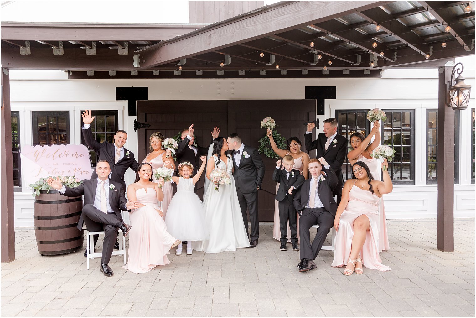 newlyweds kiss while wedding party cheers at Hamilton Manor