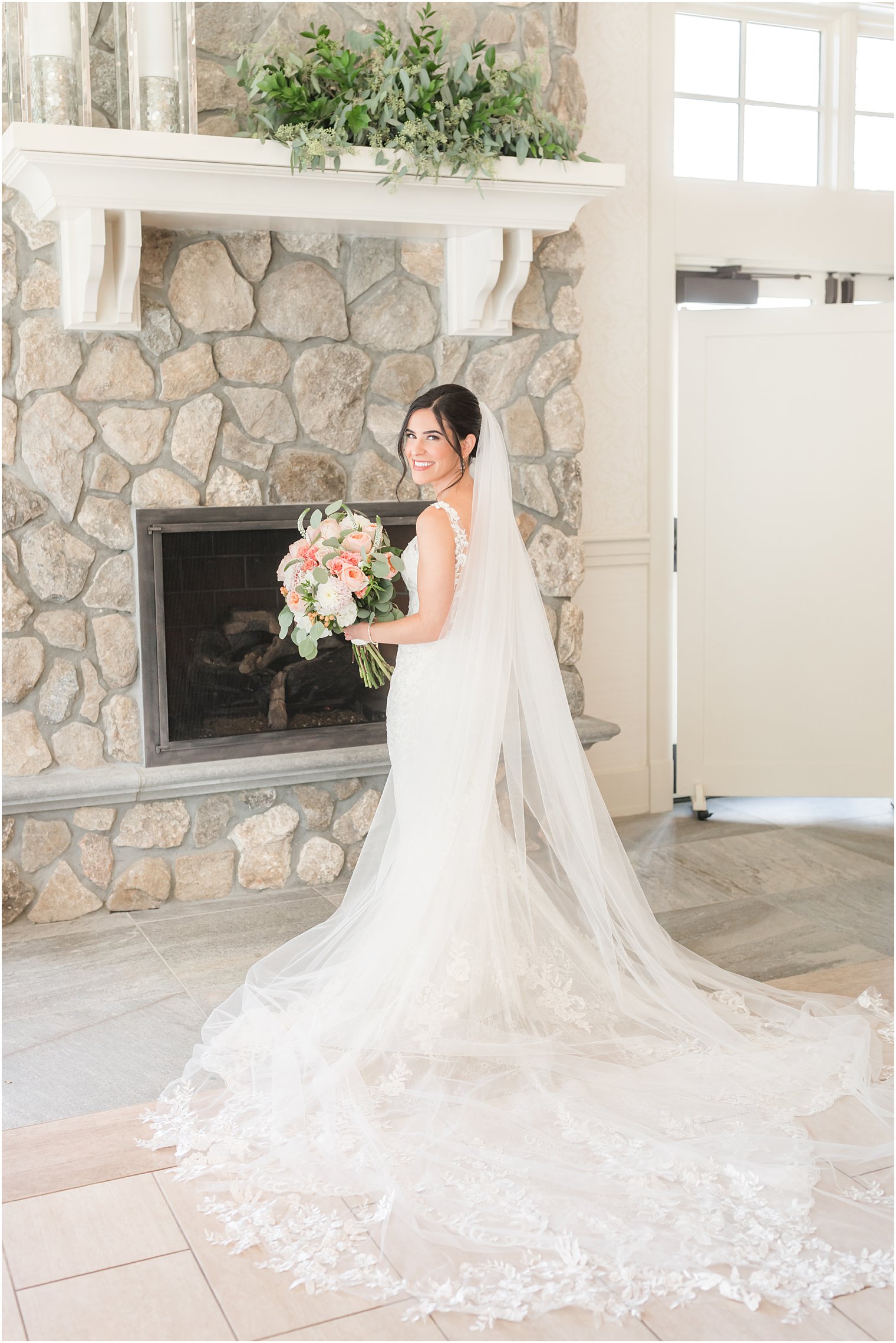 bride poses by stone fireplace at Indian Trail Club