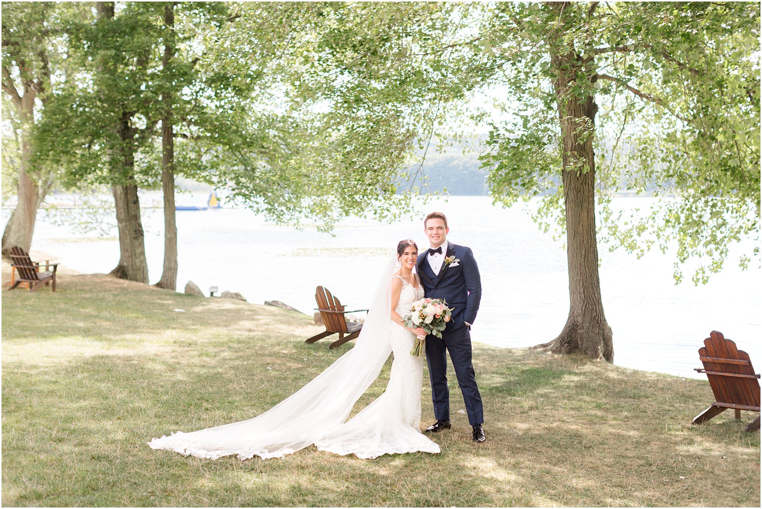 bride and groom stand together by waterfront at Indian Trail Club