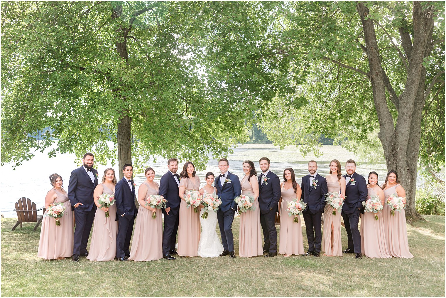 newlyweds pose with wedding party in pink and navy blue