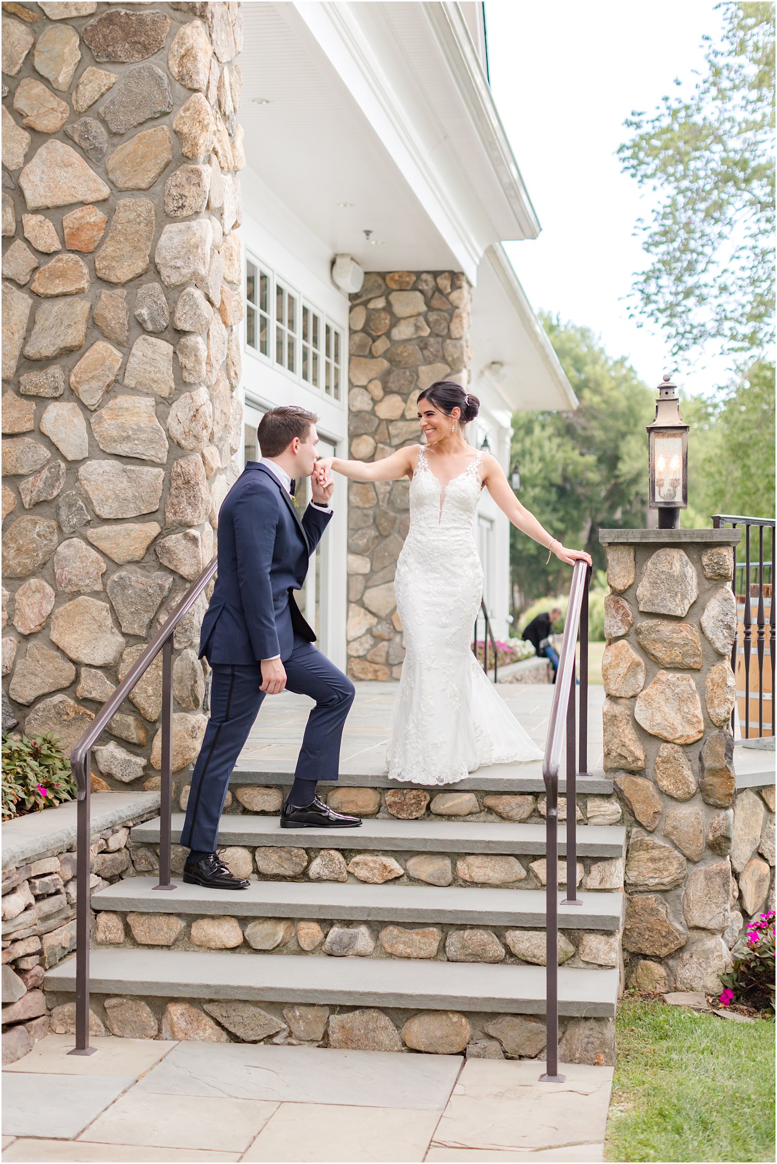 groom leads bride down stone steps outside Indian Trail Club