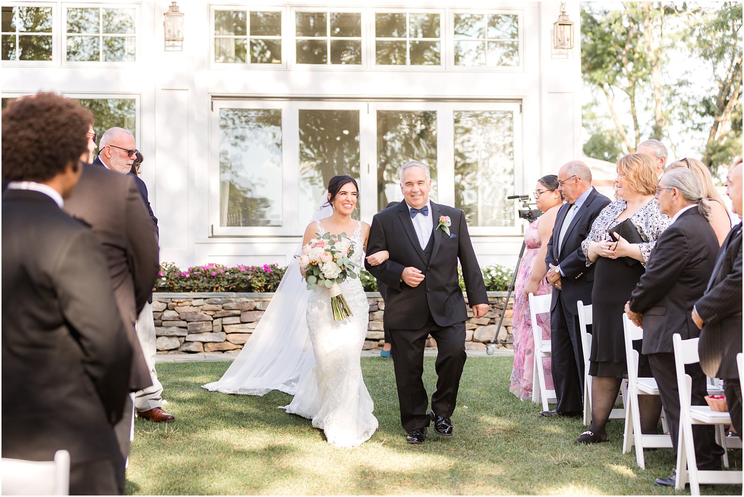 bride and father enter outdoor wedding ceremony by water in Franklin Lakes NJ