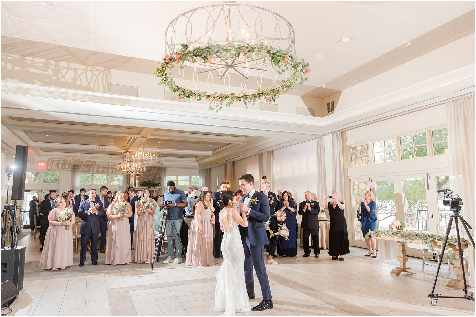 bride and groom dance under greenery chandelier