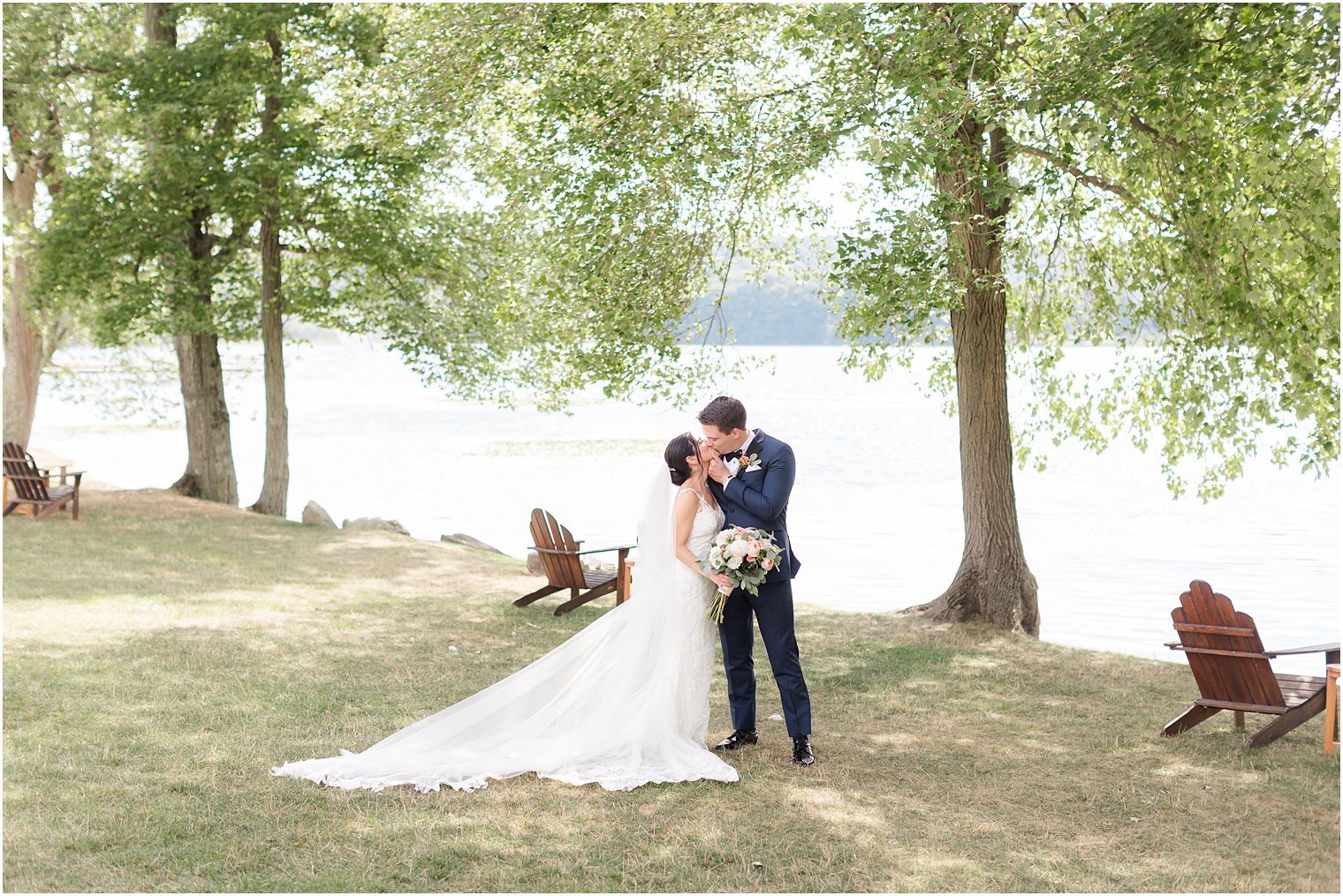 bride and groom kiss by lakefront at Indian Trail Club