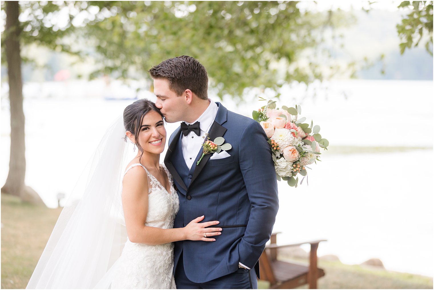 groom kisses bride's forehead during portraits at Indian Trail Club