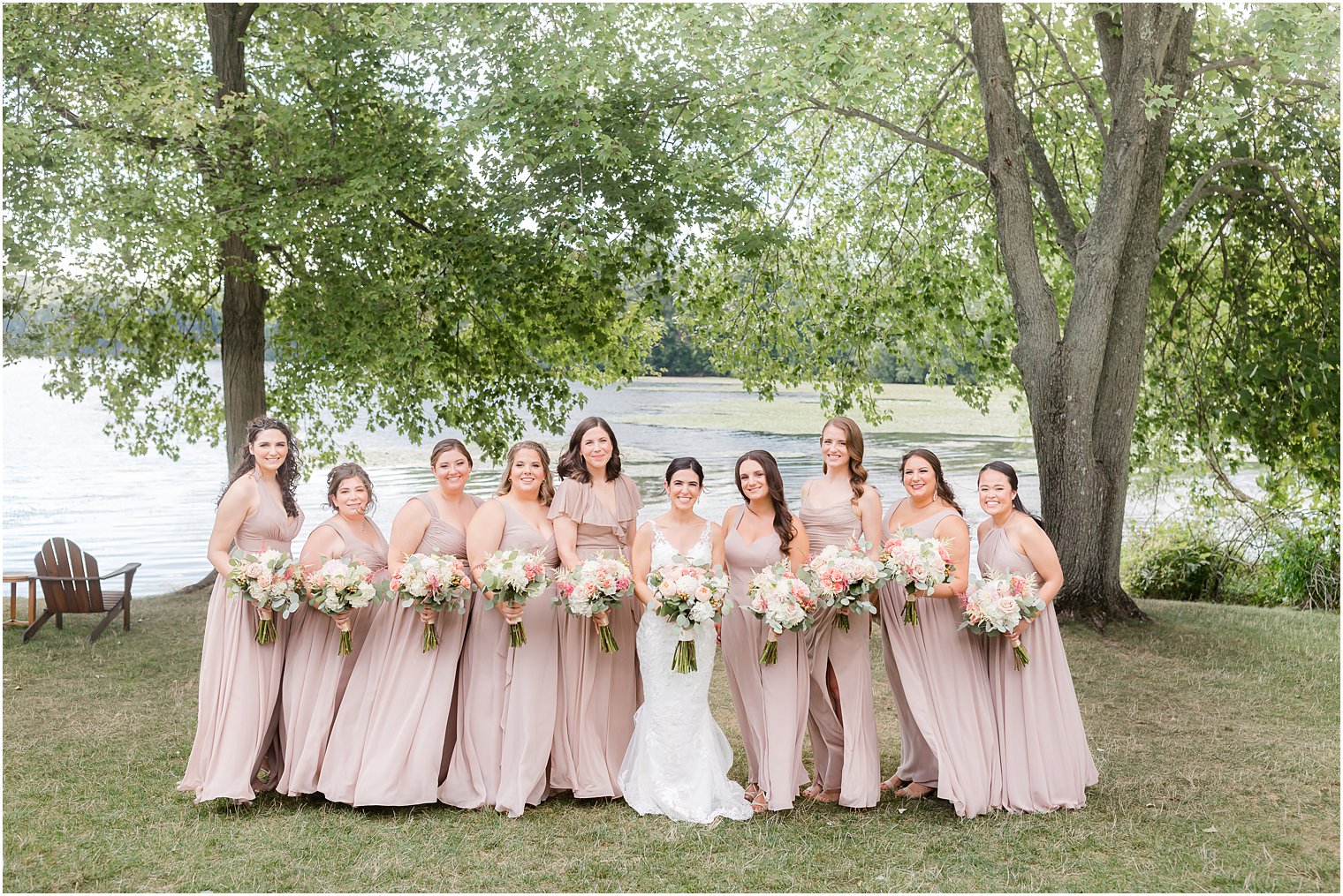 bride poses with bridesmaids in pink gowns at Indian Trail Club