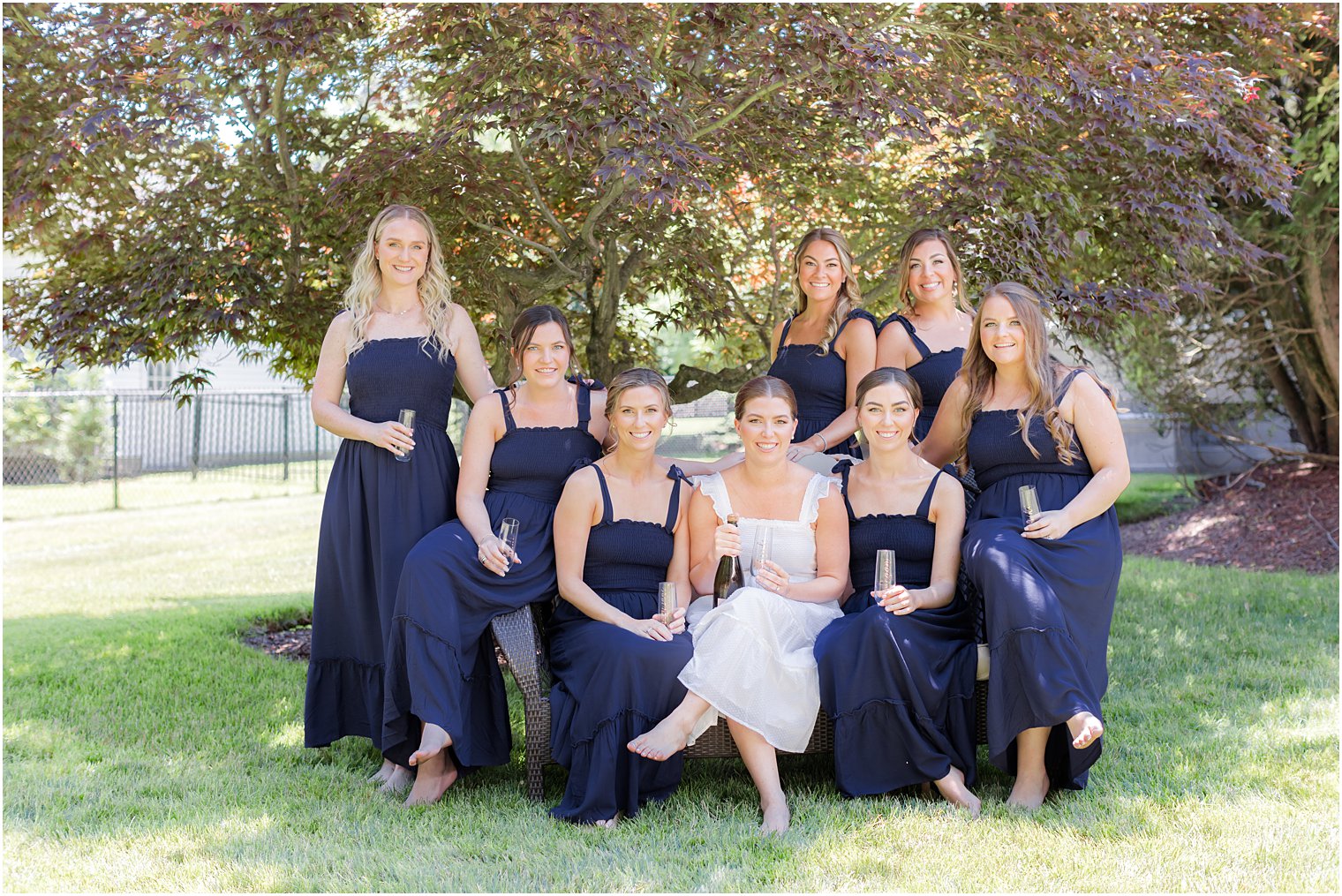 bride sits with bridesmaids in blue dresses during prep for NJ wedding