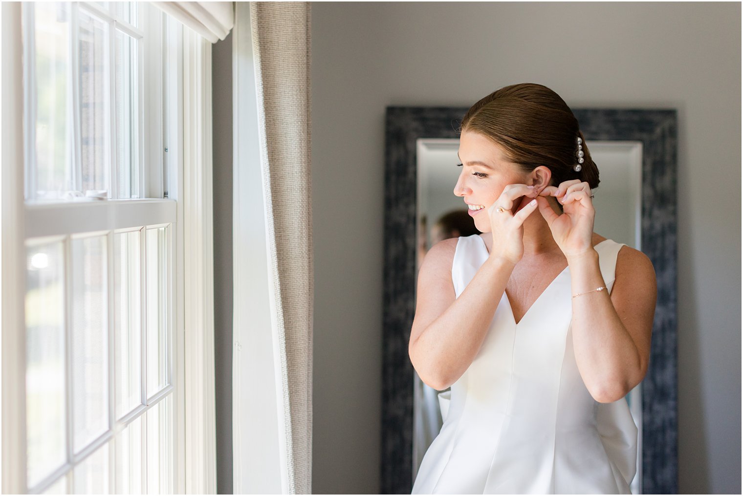 bride adjusts earrings before summer Indian Trail Club wedding