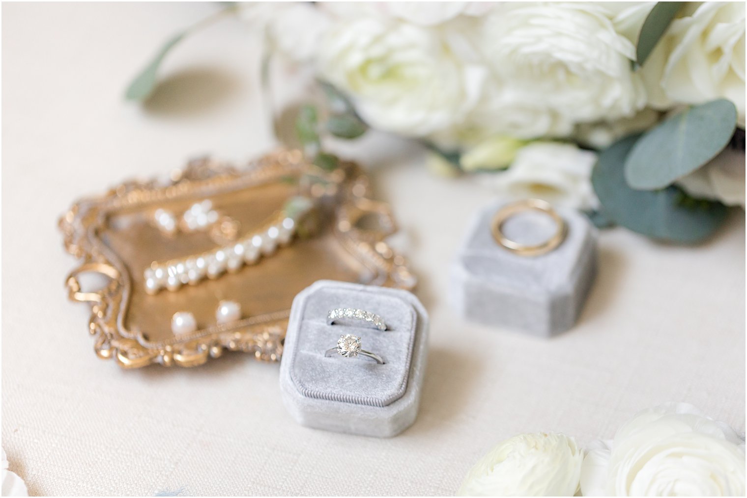 bride's jewelry in blue box and on gold tray