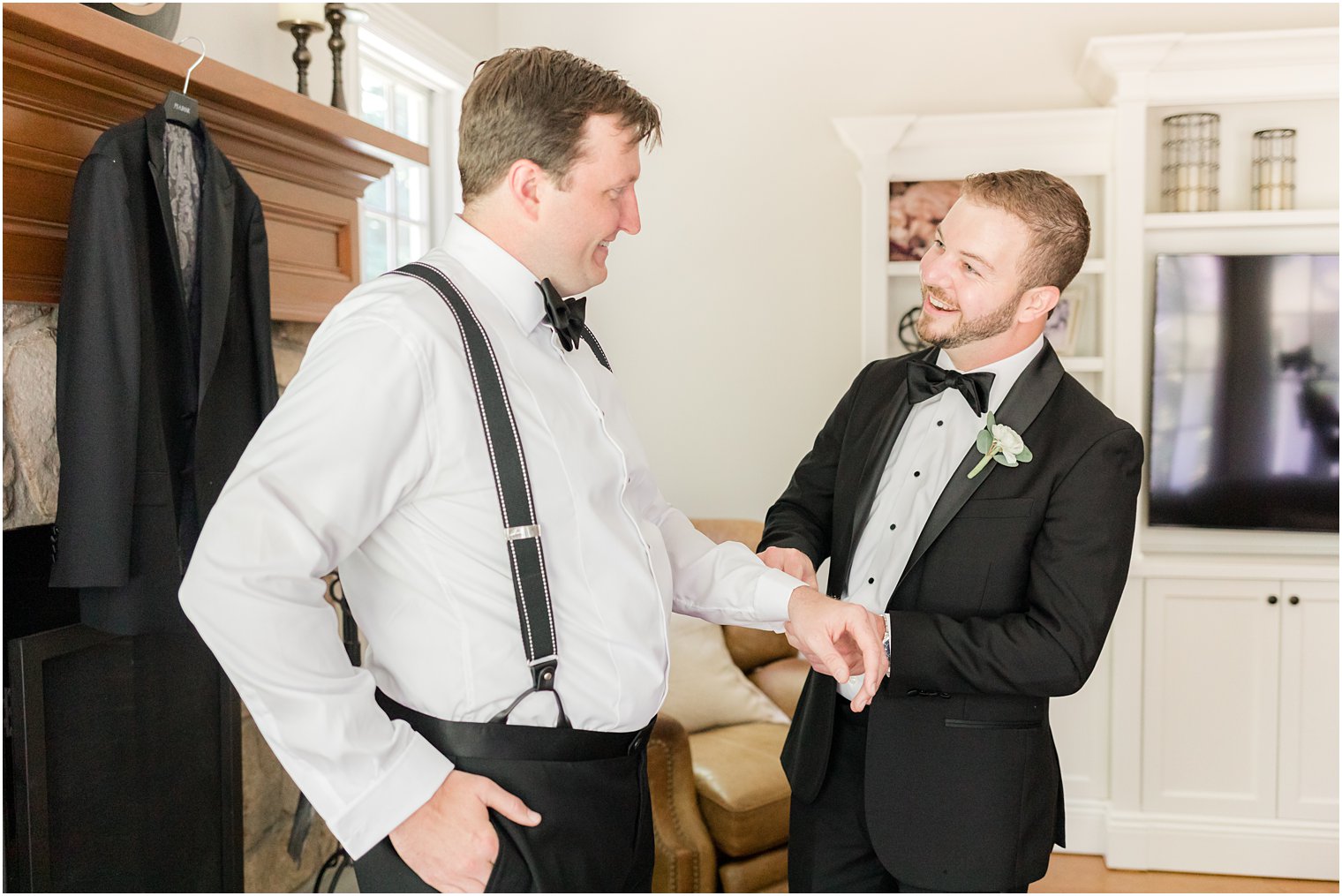 groomsman helps groom with cufflinks on wedding morning 