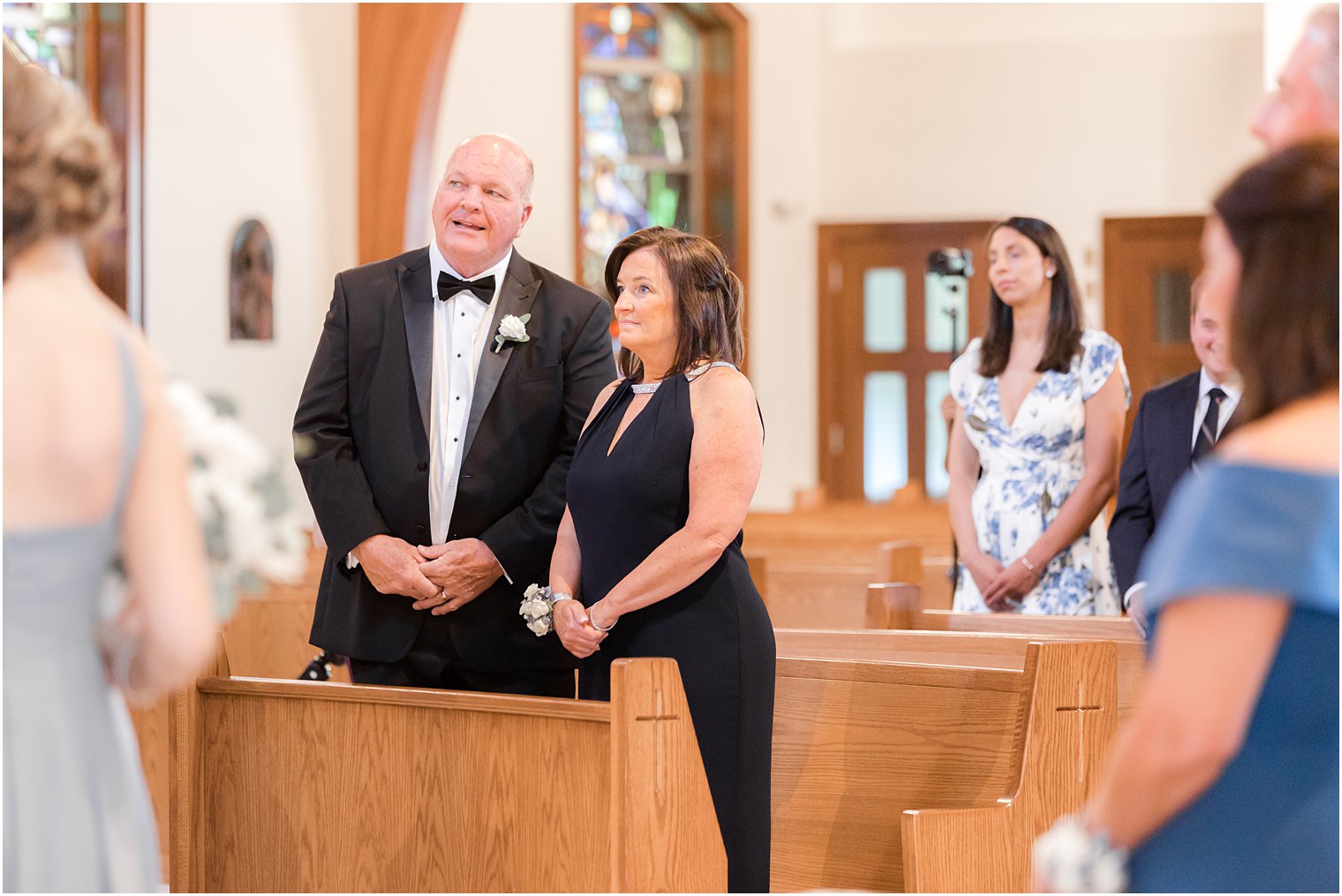 parents stand watching traditional wedding ceremony at the Church of the Presentation