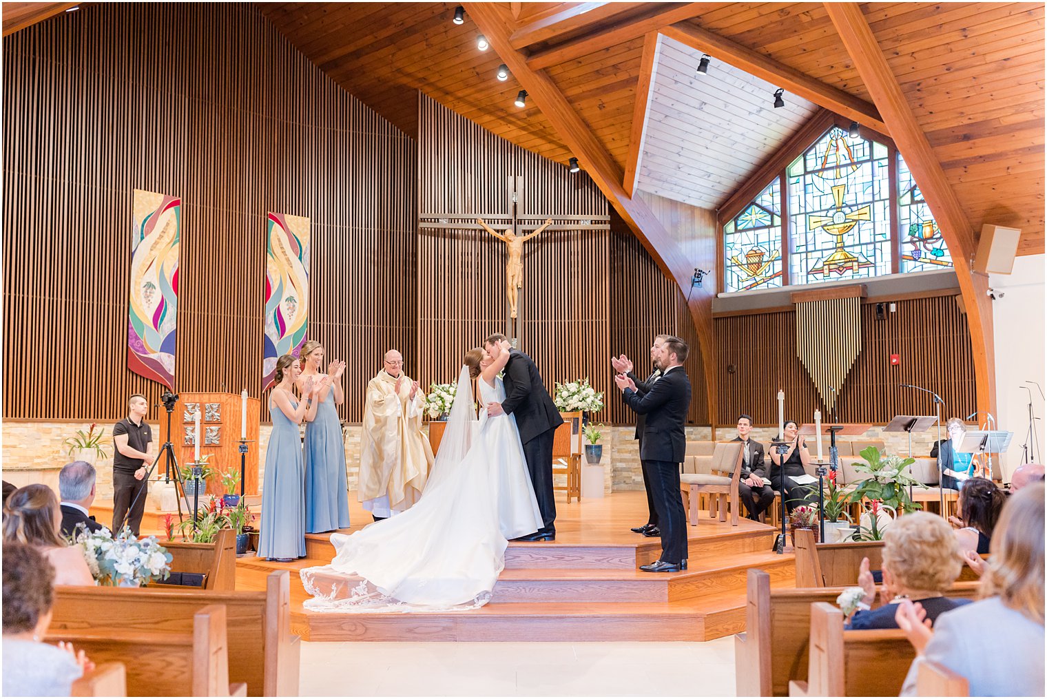 bride and groom kiss by alter during traditional wedding ceremony at the Church of the Presentation