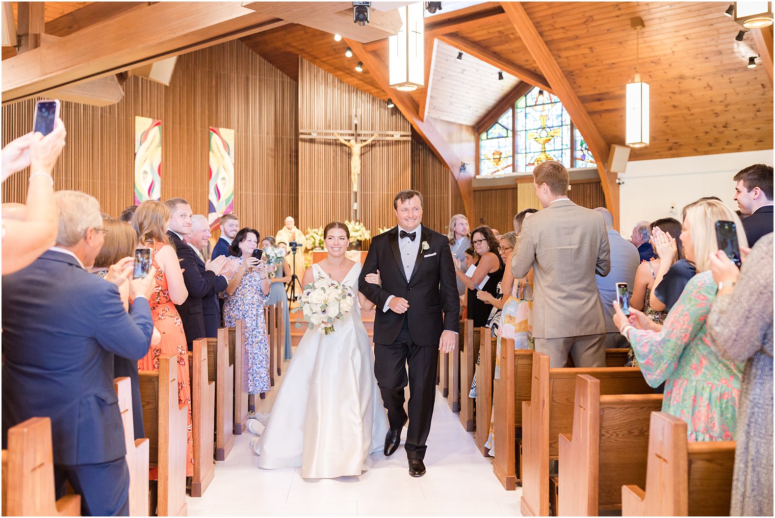 couple recesses up aisle after traditional wedding ceremony at the Church of the Presentation