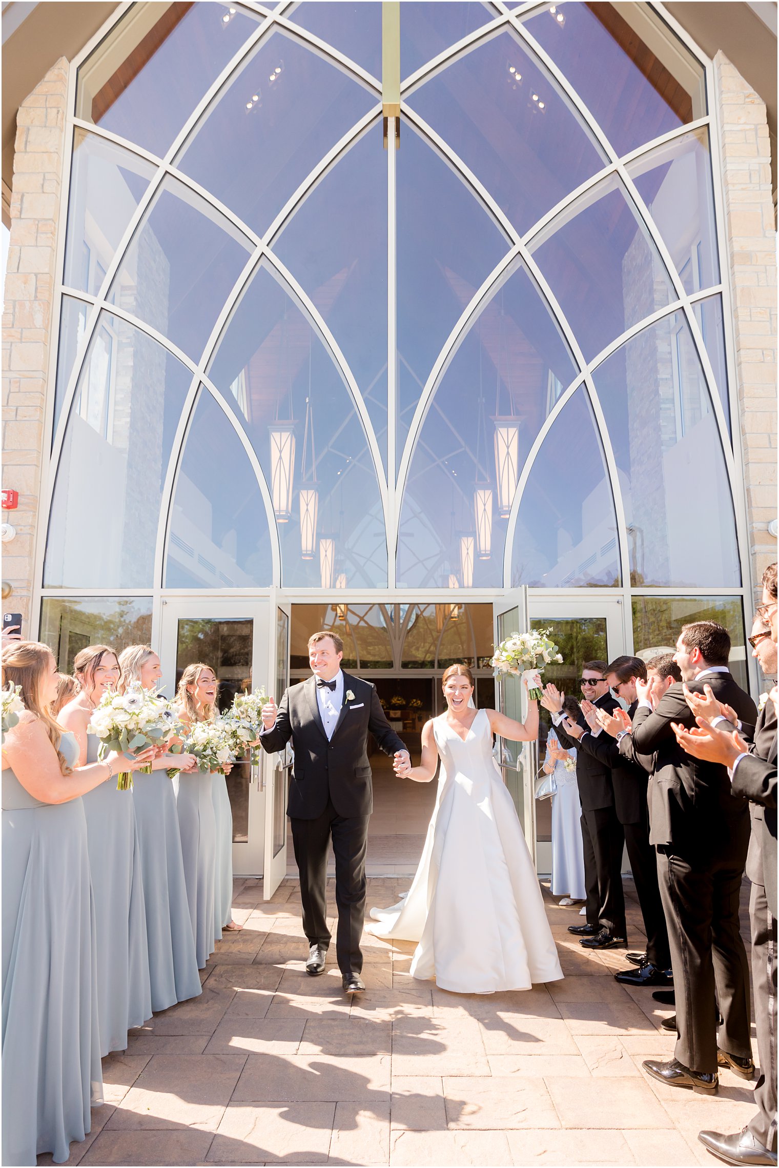 couple cheers with guests outside Church of the Presentation