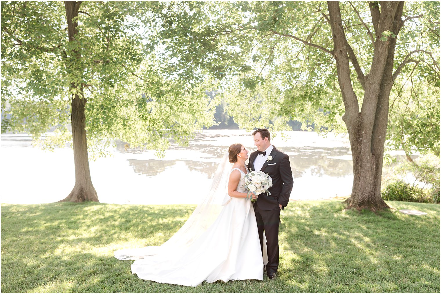 bride looks up at groom smiling during portraits at Indian Trail Club