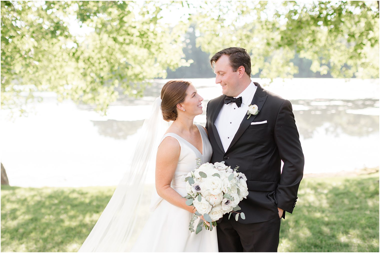 groom smiles at bride hugging her during summer Indian Trail Club photos 