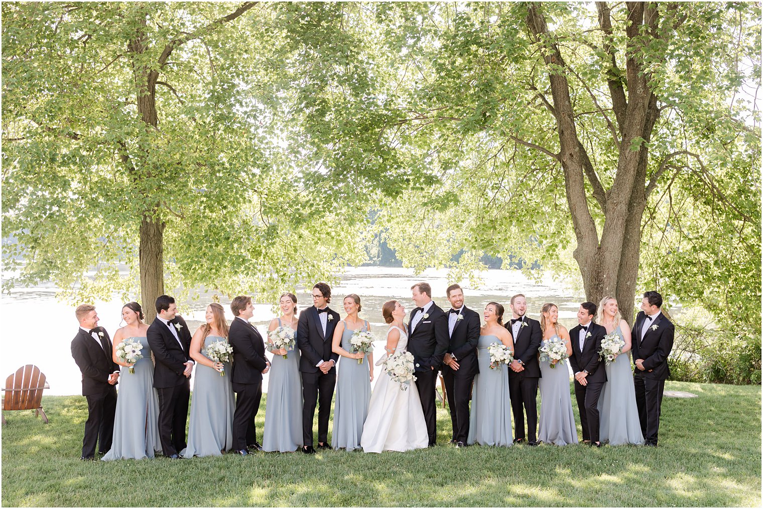 newlyweds smile at each other while wedding party looks around