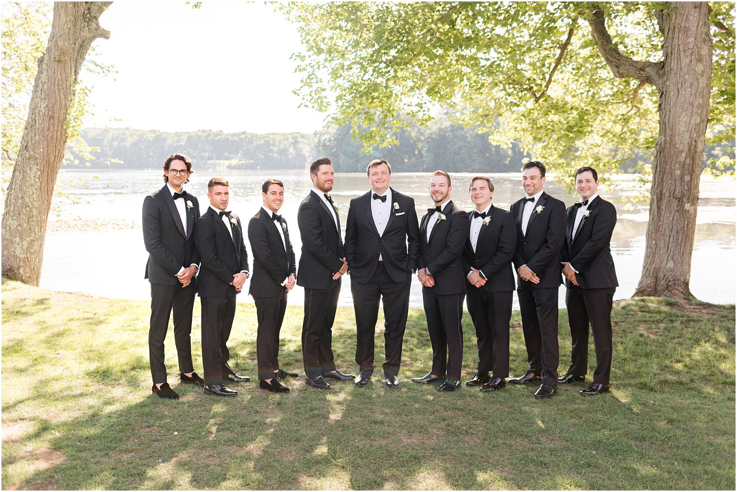 groom stands with groomsmen in classic black tuxes 