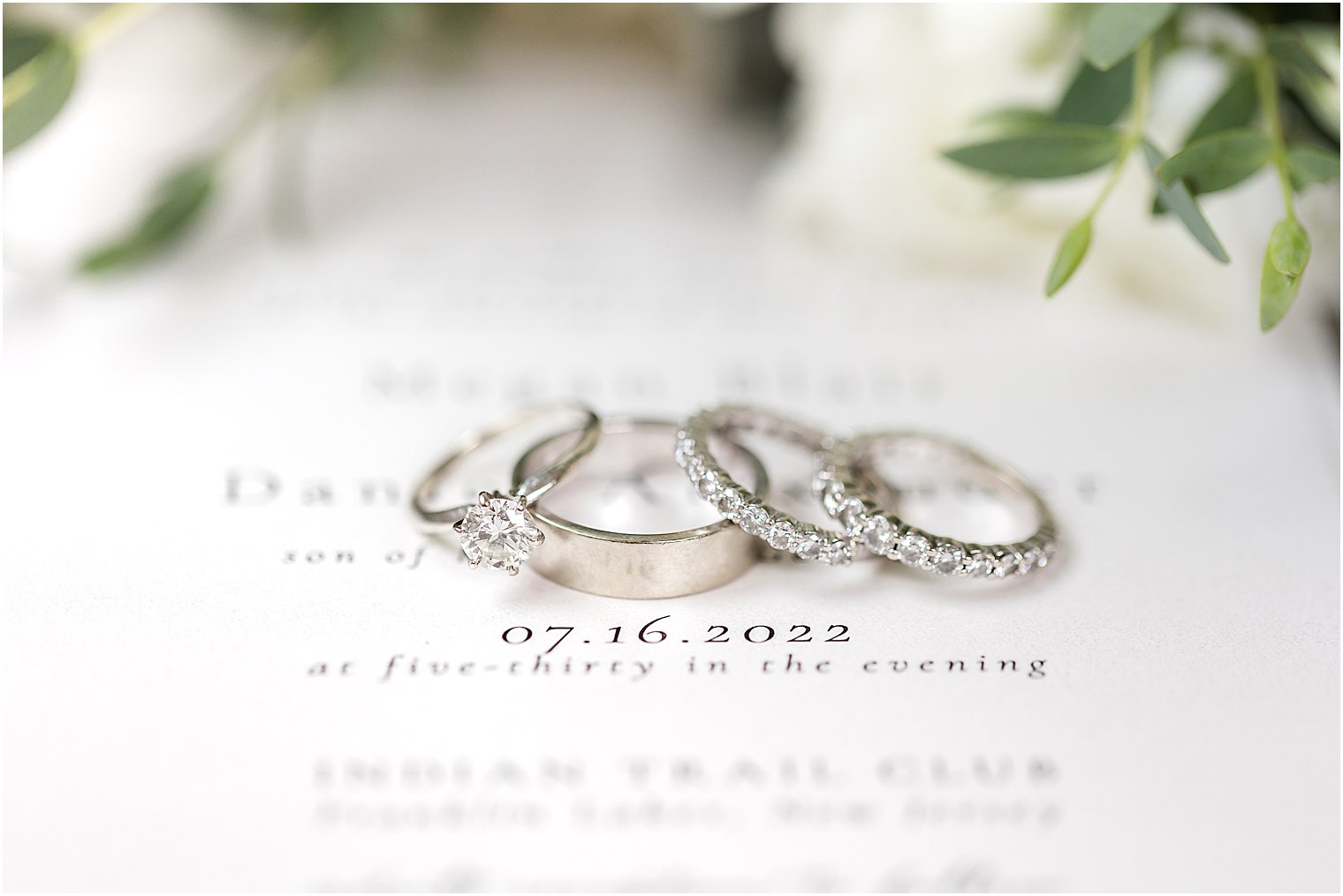 wedding rings rest on invitation suite