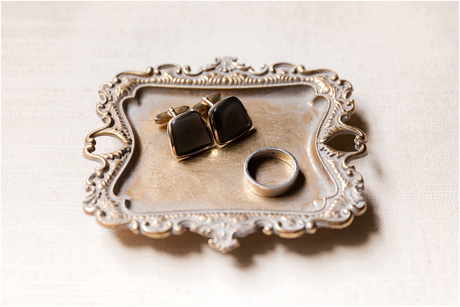 groom's details rest on gold tray