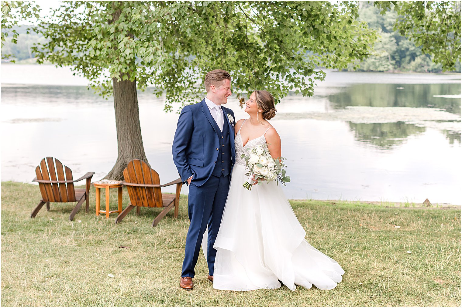 bride and groom smile together along waterfront at Indian Trail Club