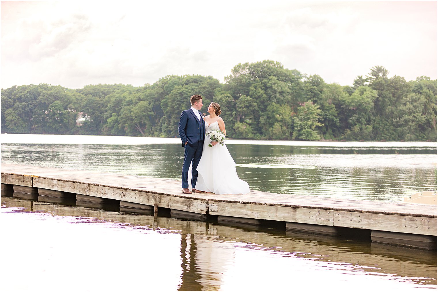 bride and groom stand on dock at Indian Trail Club