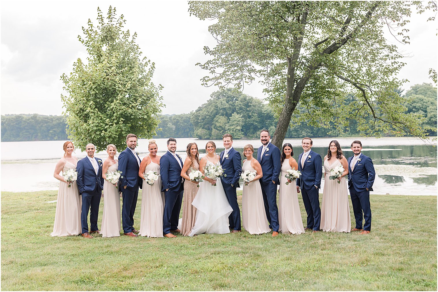 bride and groom pose with wedding party in mauve and navy