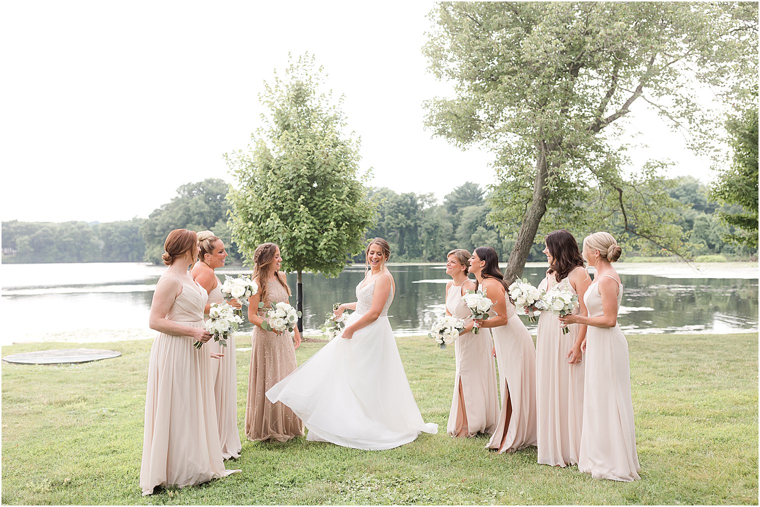 bride twirls wedding dress with bridesmaids around her