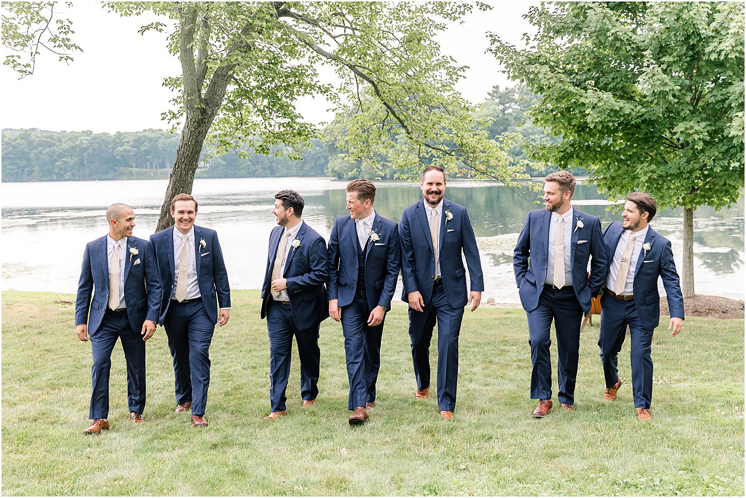 groom walks with groomsmen in navy suits