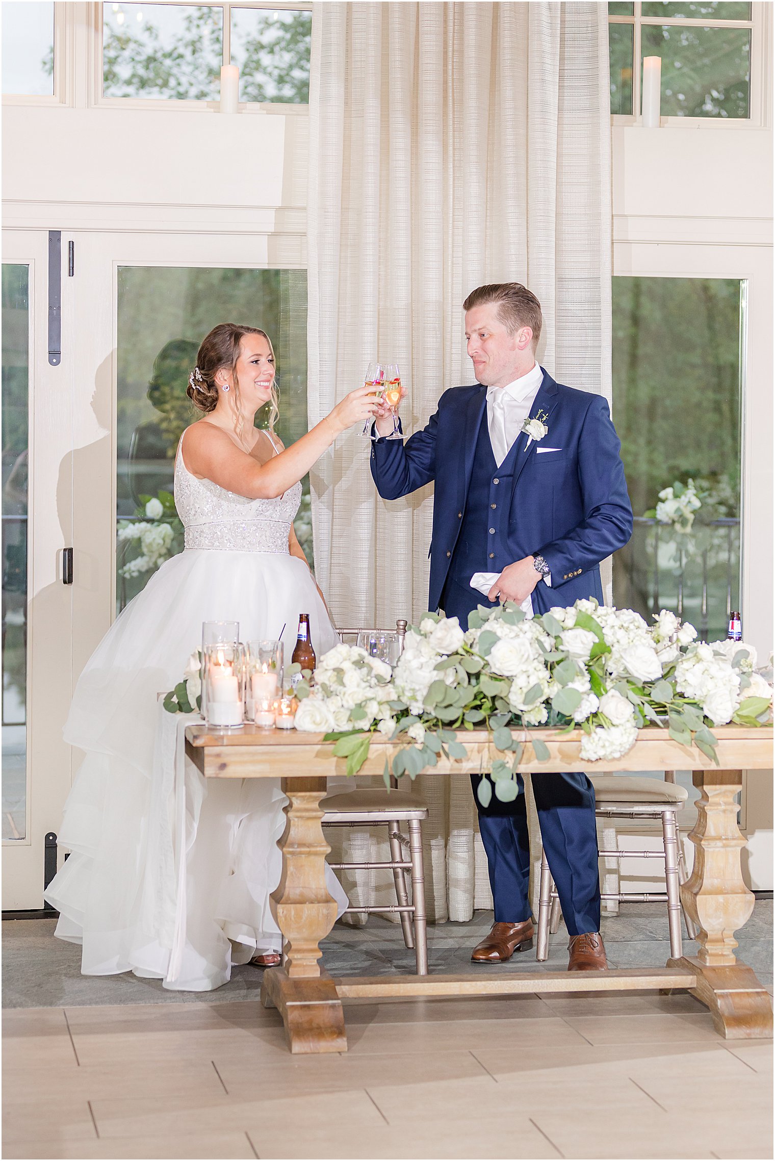 newlyweds toast champagne at sweetheart table