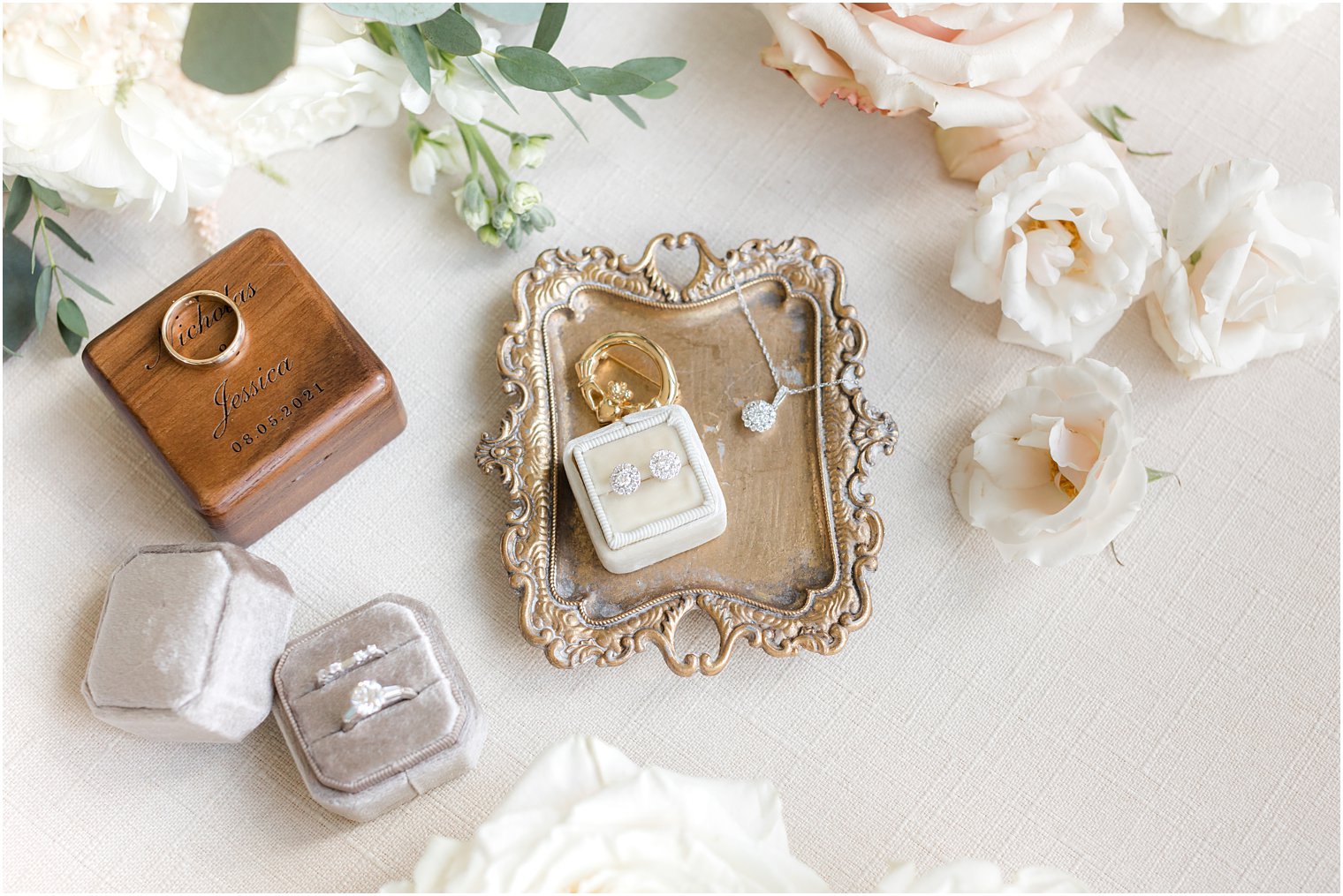 wedding rings and jewelry rest on gold tray