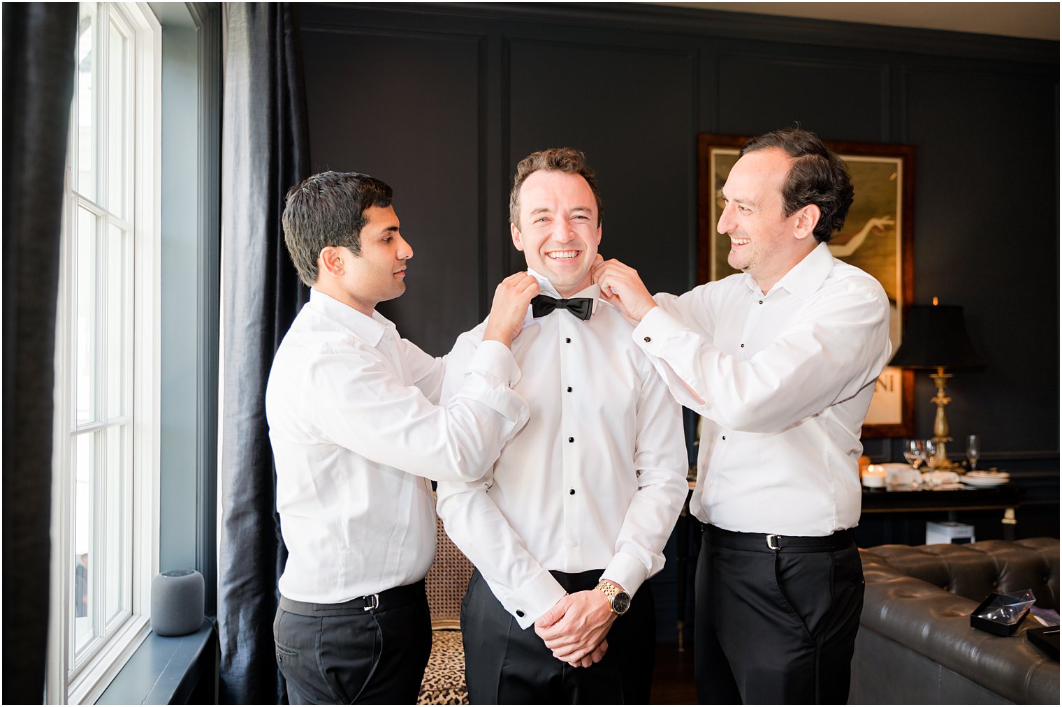 groomsmen help groom with black bowtie at Park Chateau Estate
