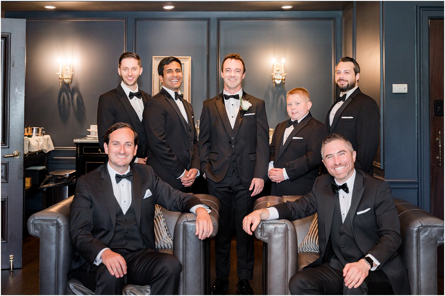 groom poses with groomsmen in groom's suite at Park Chateau Estate