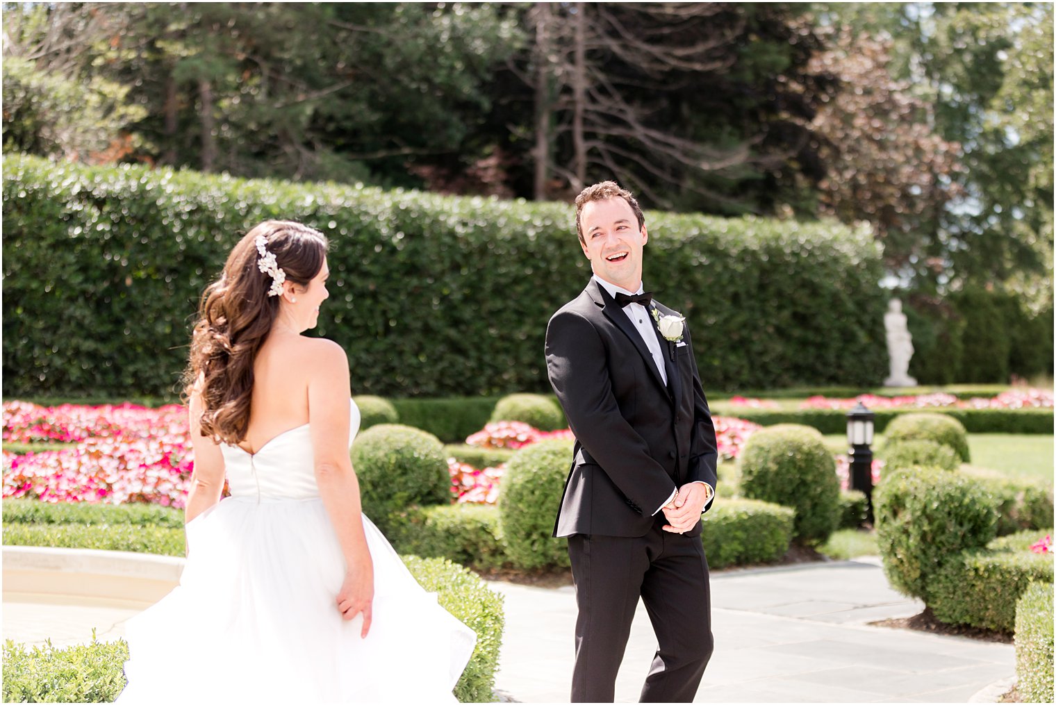 groom turns to look at bride in French gardens for first look