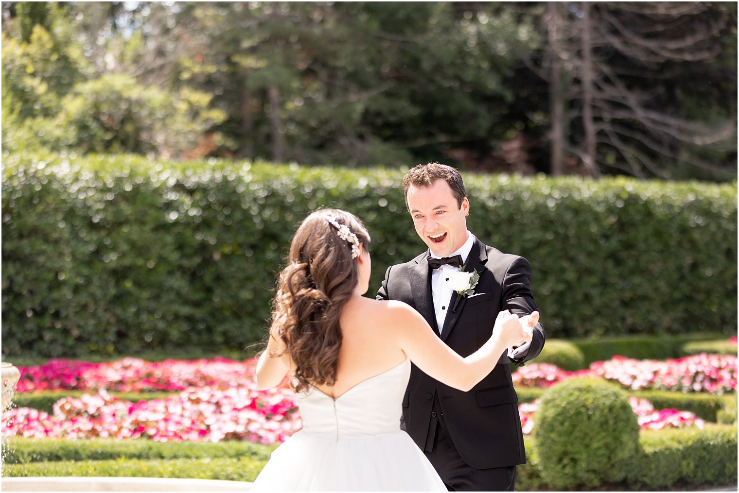 groom smiles at bride during Park Chateau Estate first look in garden