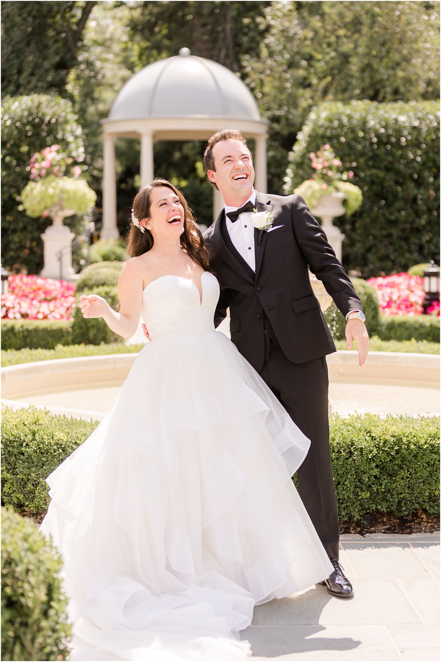 newlyweds smile together up at bridal party during wedding portraits 