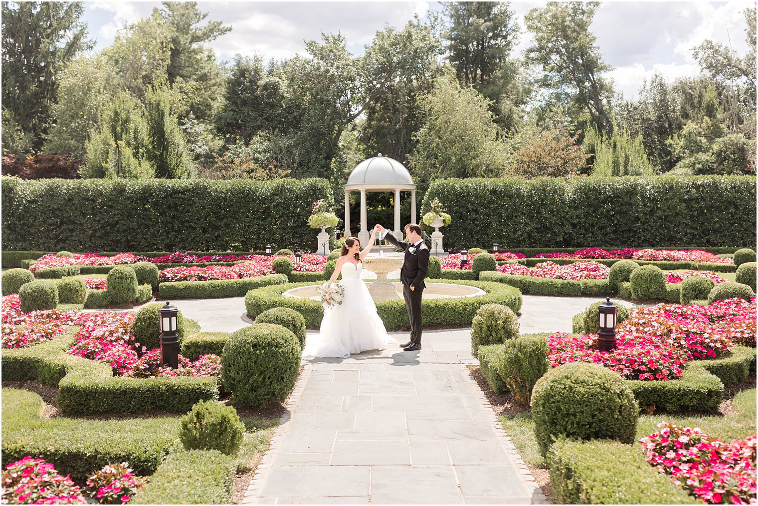 newlyweds walk in French gardens at Park Chateau Estate