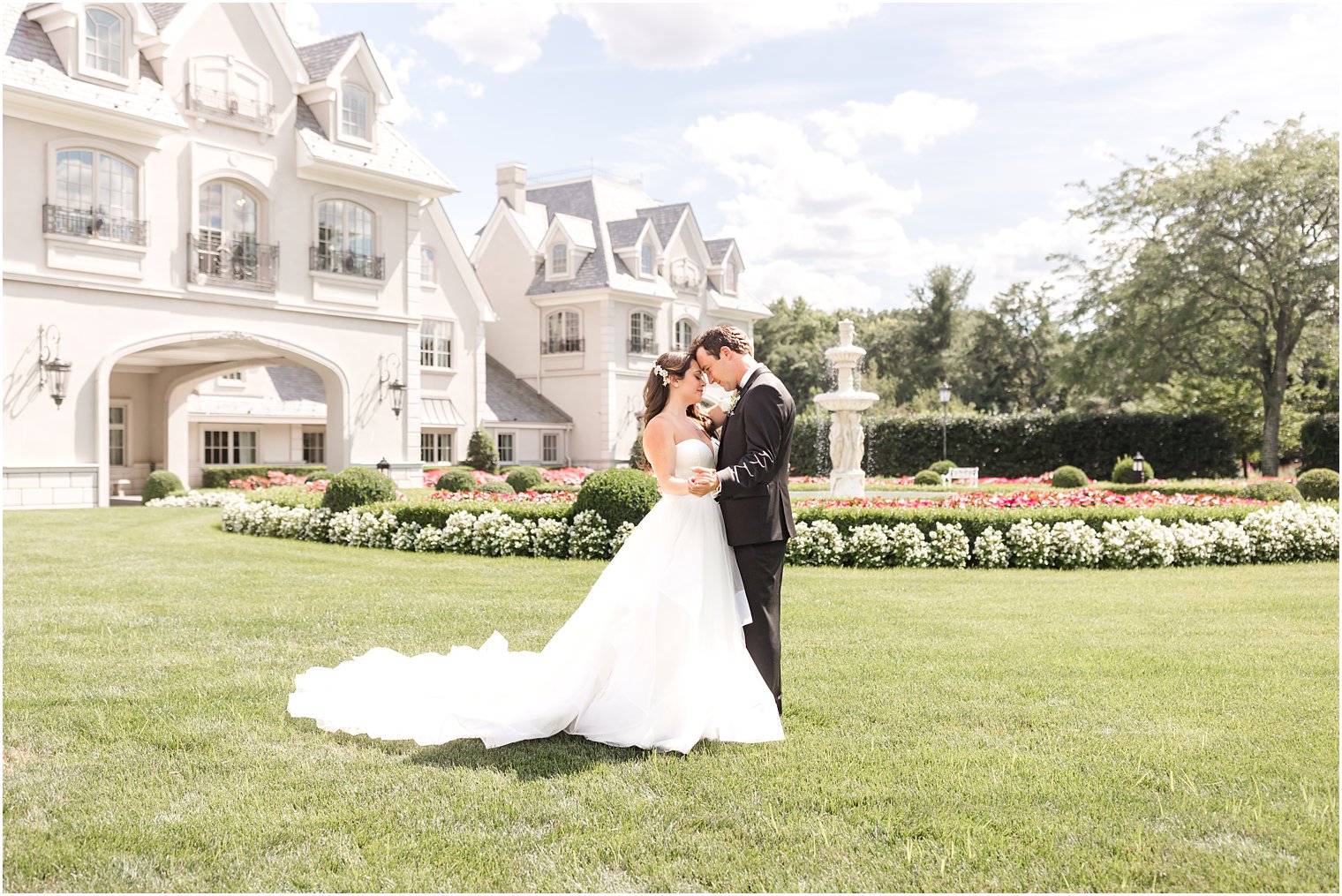 newlyweds stand together on lawn at Park Chateau Estate
