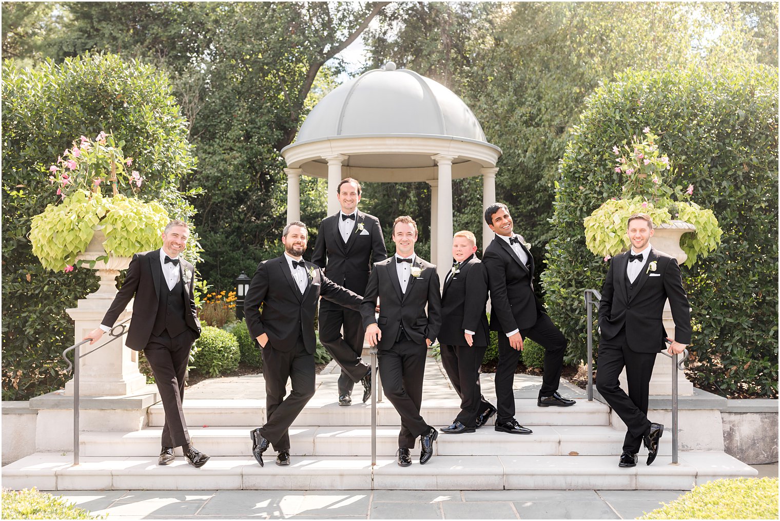 groom and groomsmen stand in front of gazebo at Park Chateau Estate
