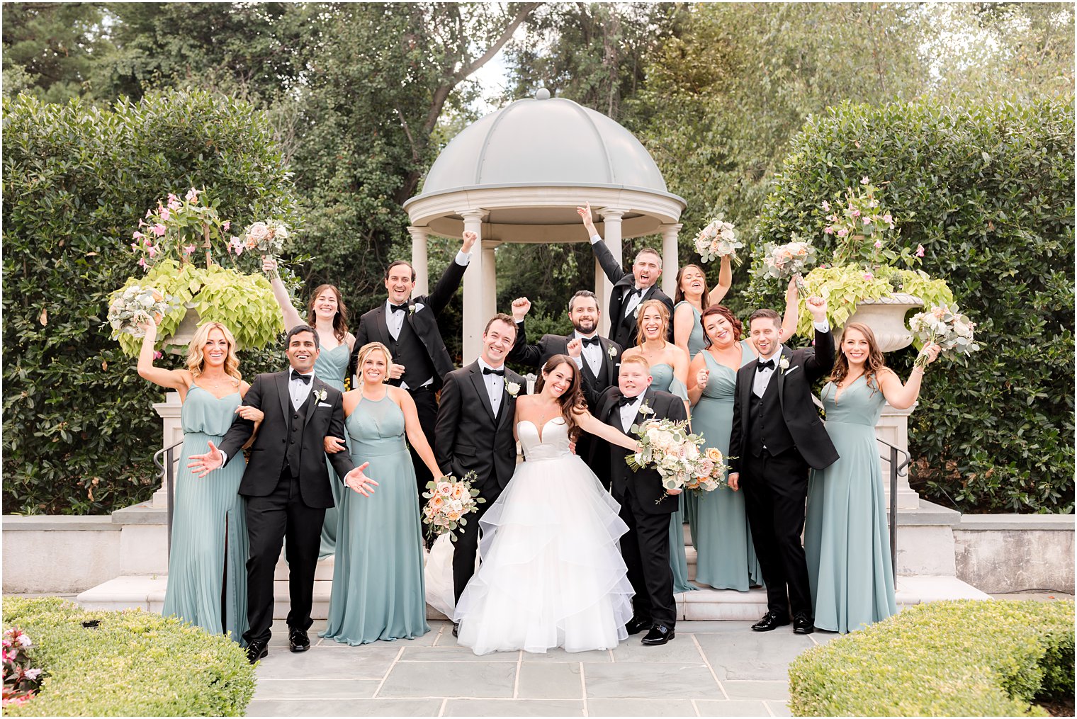 bride and groom pose with wedding party by gazebo at Park Chateau Estate